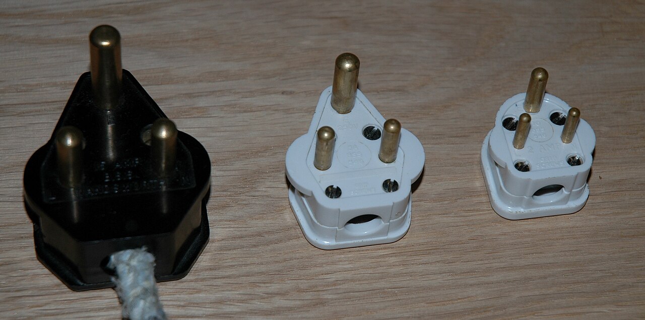 BS 546 plugs: black 15A Type M at left, white 5A Type D in the centre, and white 2A at right