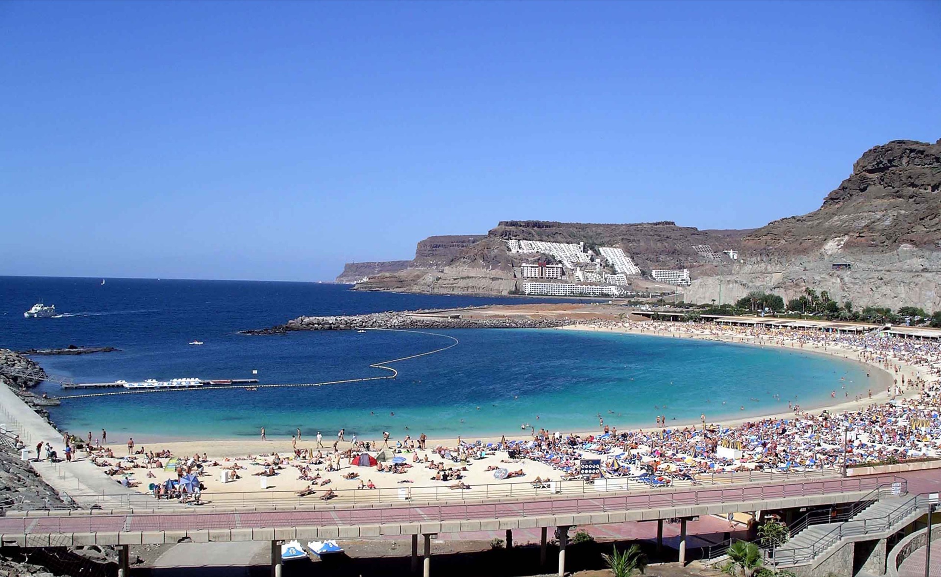 Amadores beach in southwest Gran Canaria, with a curved bay, breakwaters and hillside accommodation