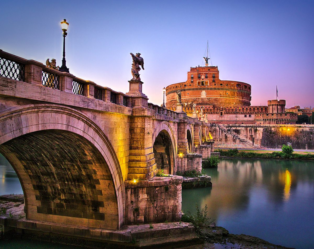 Castel Sant’Angelo and its bridge reflected in the Tiber at dusk