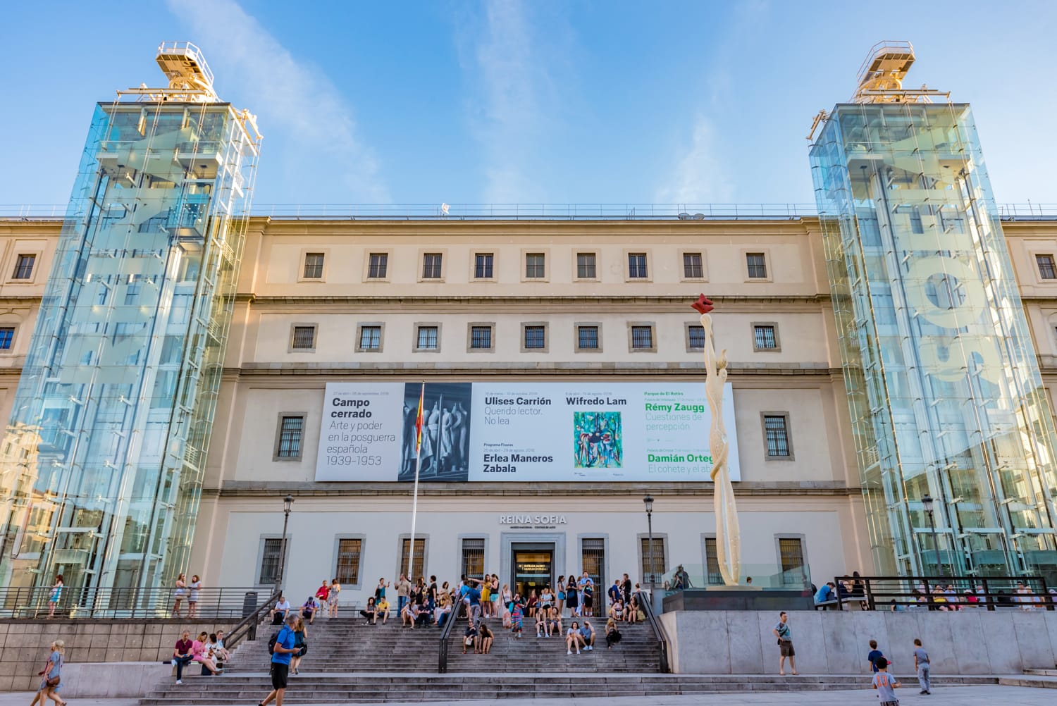 Reina Sofía Museum in Madrid – modern art museum façade with glass elevators and visitors on the main staircase