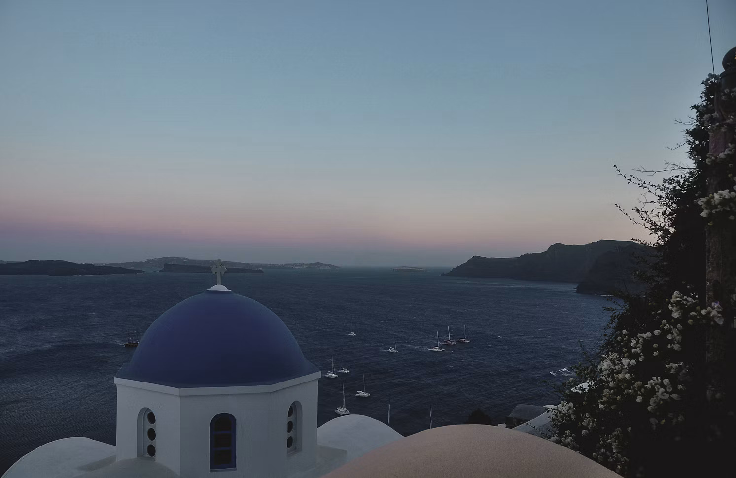 Romantic sunset in Santorini Whitewashed church and caldera at sunset in Santorini Greece