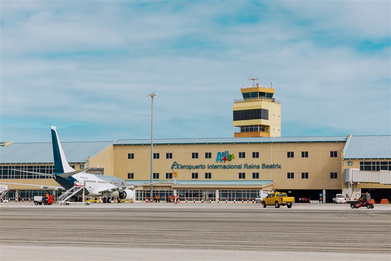Exterior view of Aruba Queen Beatrix International Airport terminal with airplane on the tarmac