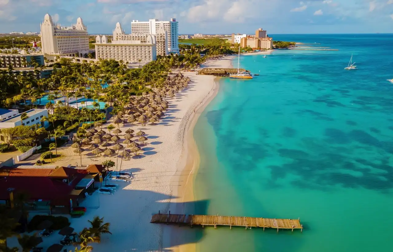 Aerial view of Palm Beach in Aruba with high-rise resorts, white sand and turquoise Caribbean Sea