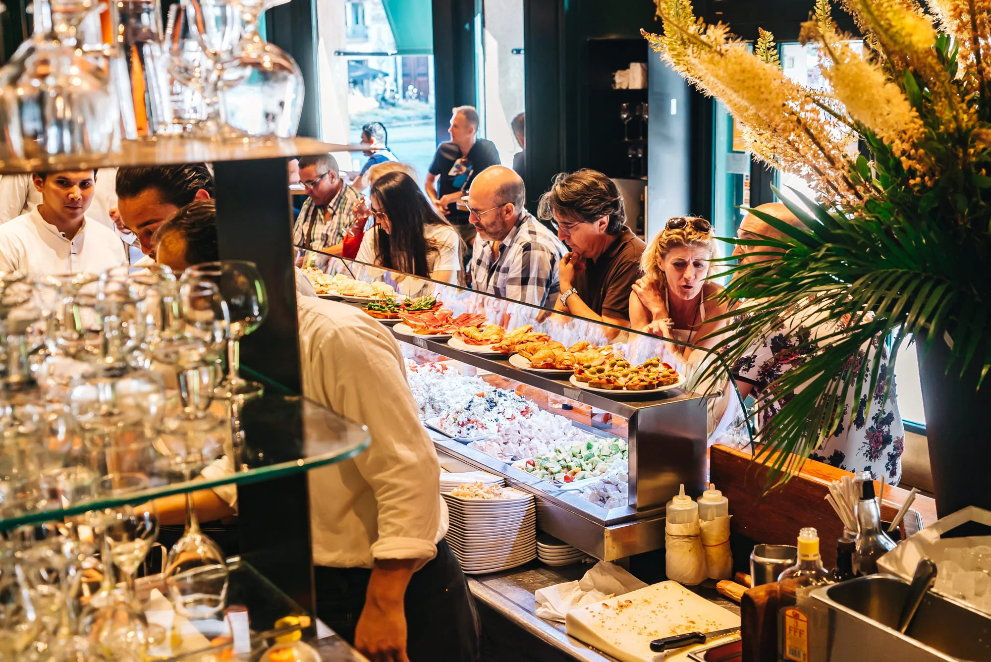 Busy tapas bar in Barcelona with locals enjoying traditional Catalan dishes
