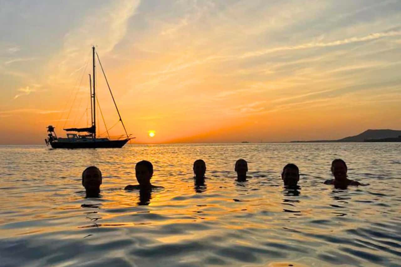 Sunset over a beach in the Canary Islands with silhouettes of people and boats