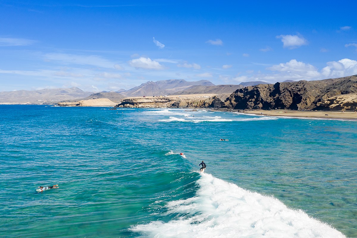 Surfer riding Atlantic waves in Fuerteventura under bright sun
