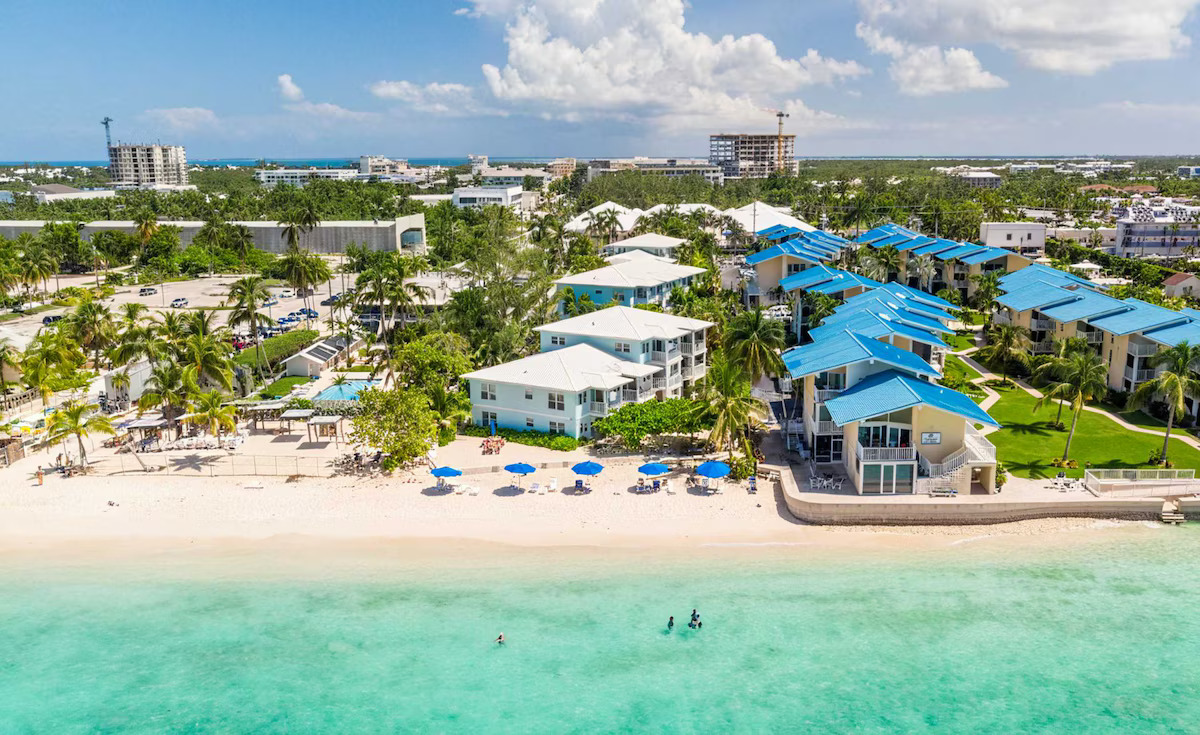 Aerial view of beachfront resorts and condos along Seven Mile Beach in Grand Cayman with turquoise waters