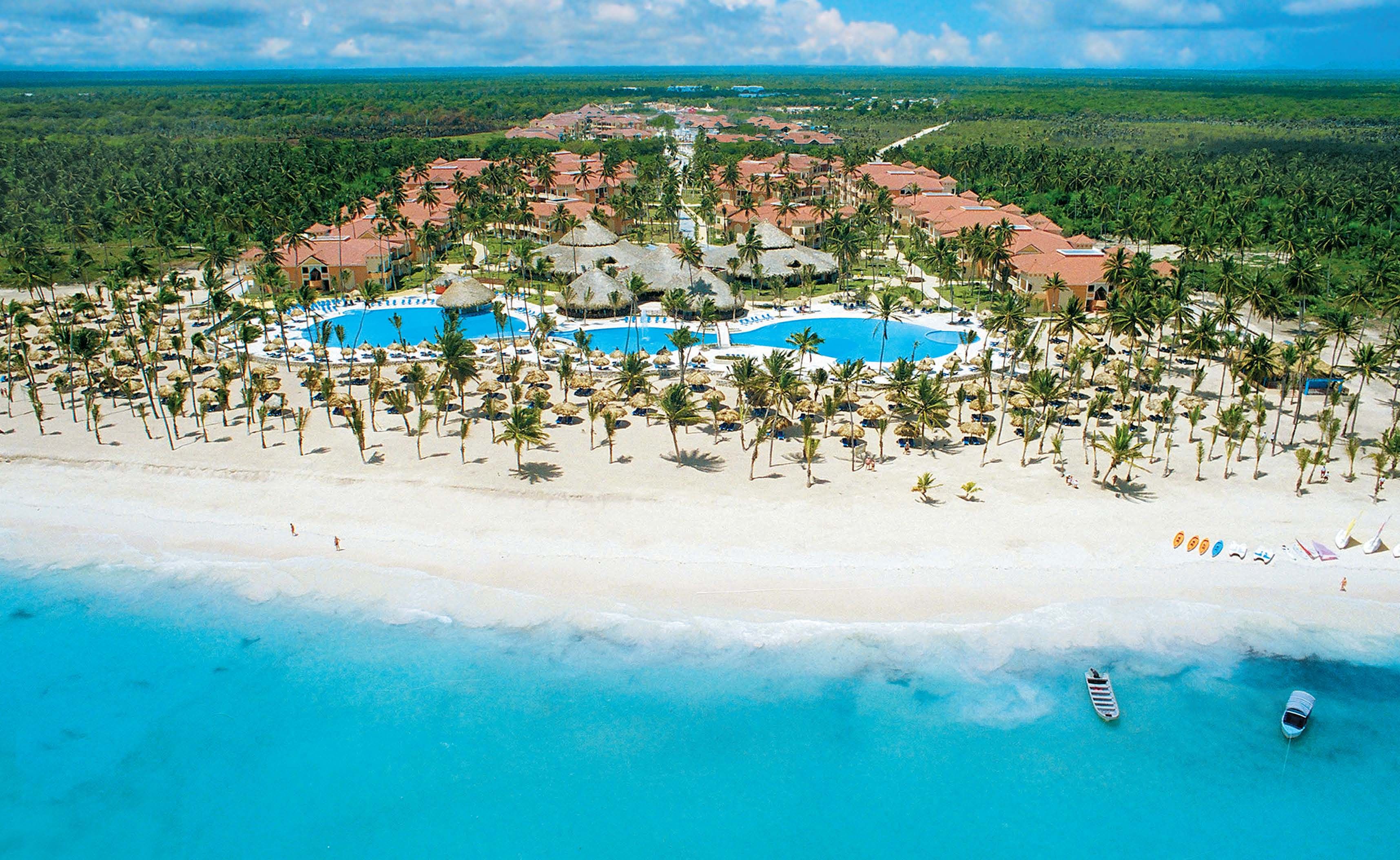 Beachfront resort accommodation in the Dominican Republic with palm-lined shoreline, white sand beach and turquoise Caribbean waters