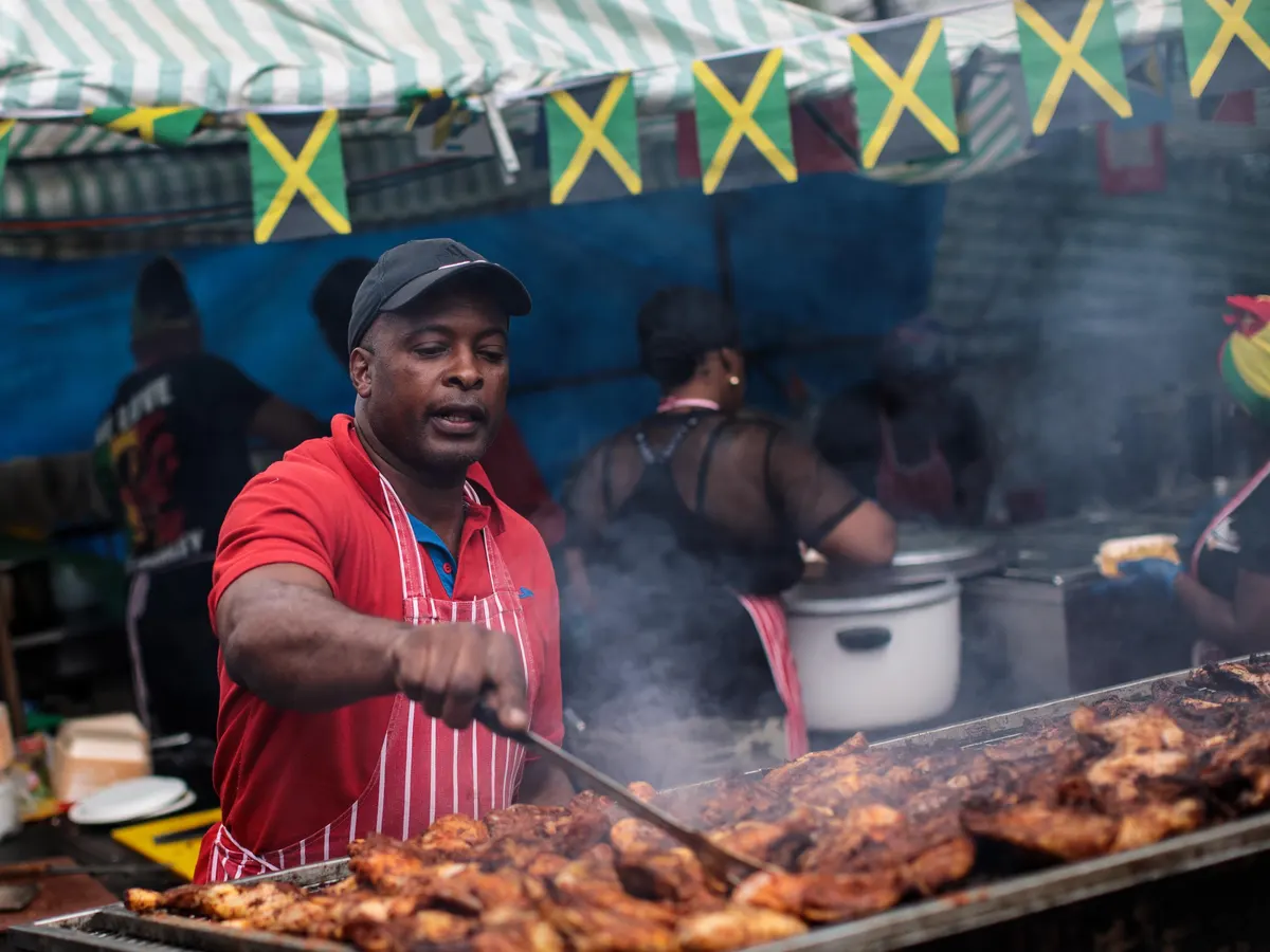 Jamaican jerk chicken being grilled at a local street food stall, representing Jamaica’s food and drink culture