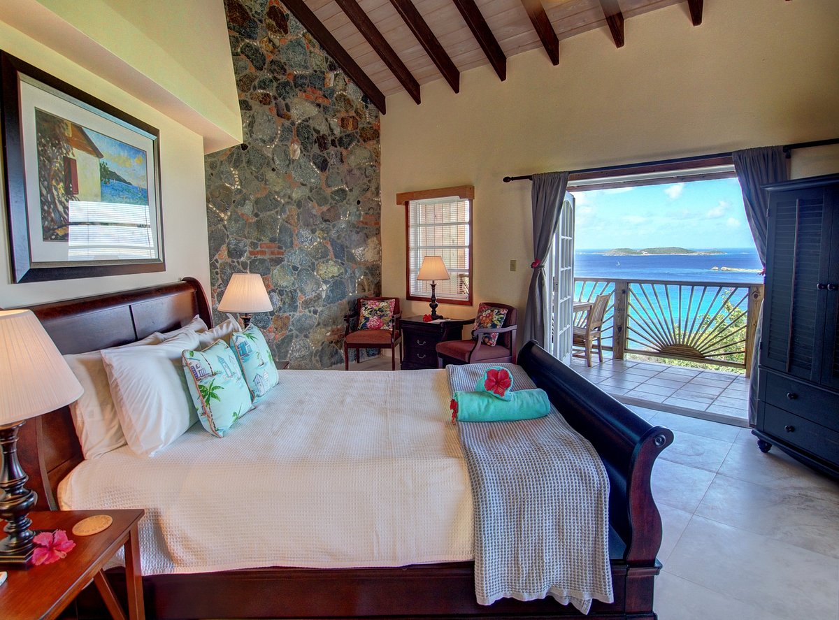 Bright bedroom with open doors to a terrace overlooking the ocean in the Virgin Islands