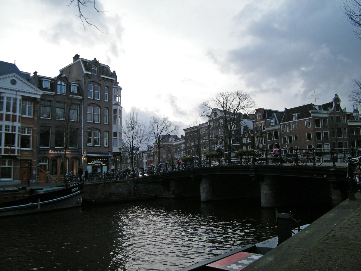 A bridge and canal-side streets in Amsterdam. A bridge and canal-side streets in Amsterdam.