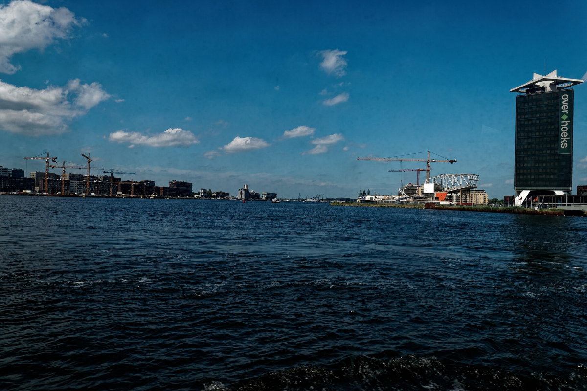 The IJ waterfront and former Shell tower seen from a passenger ferry. The IJ waterfront and former Shell tower seen from a passenger ferry.
