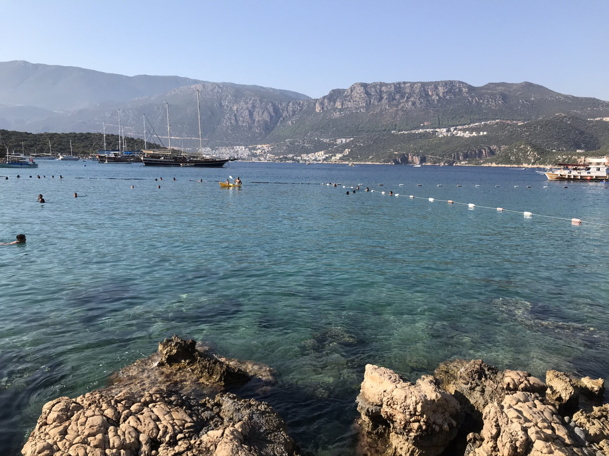 Swimmers and boats in the clear water at Limanağzı near Kaş