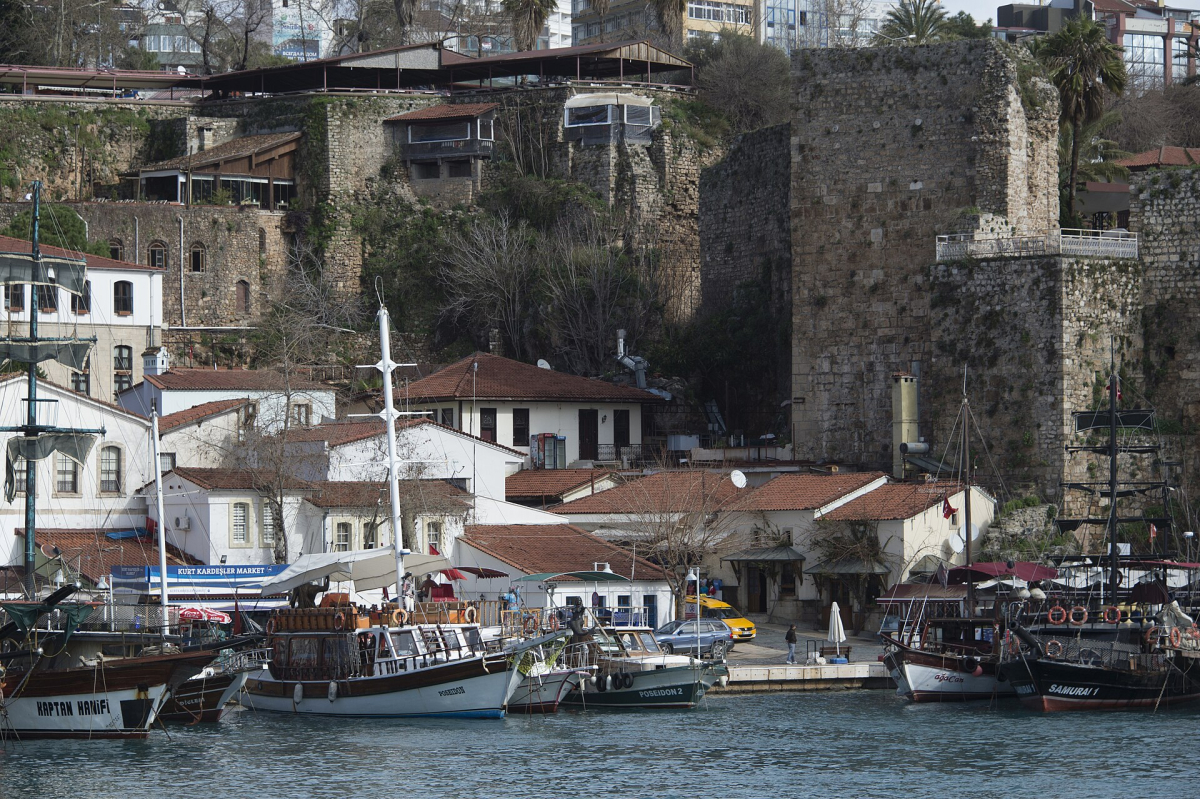 Boats moored beneath the stone walls of Antalya’s old harbour