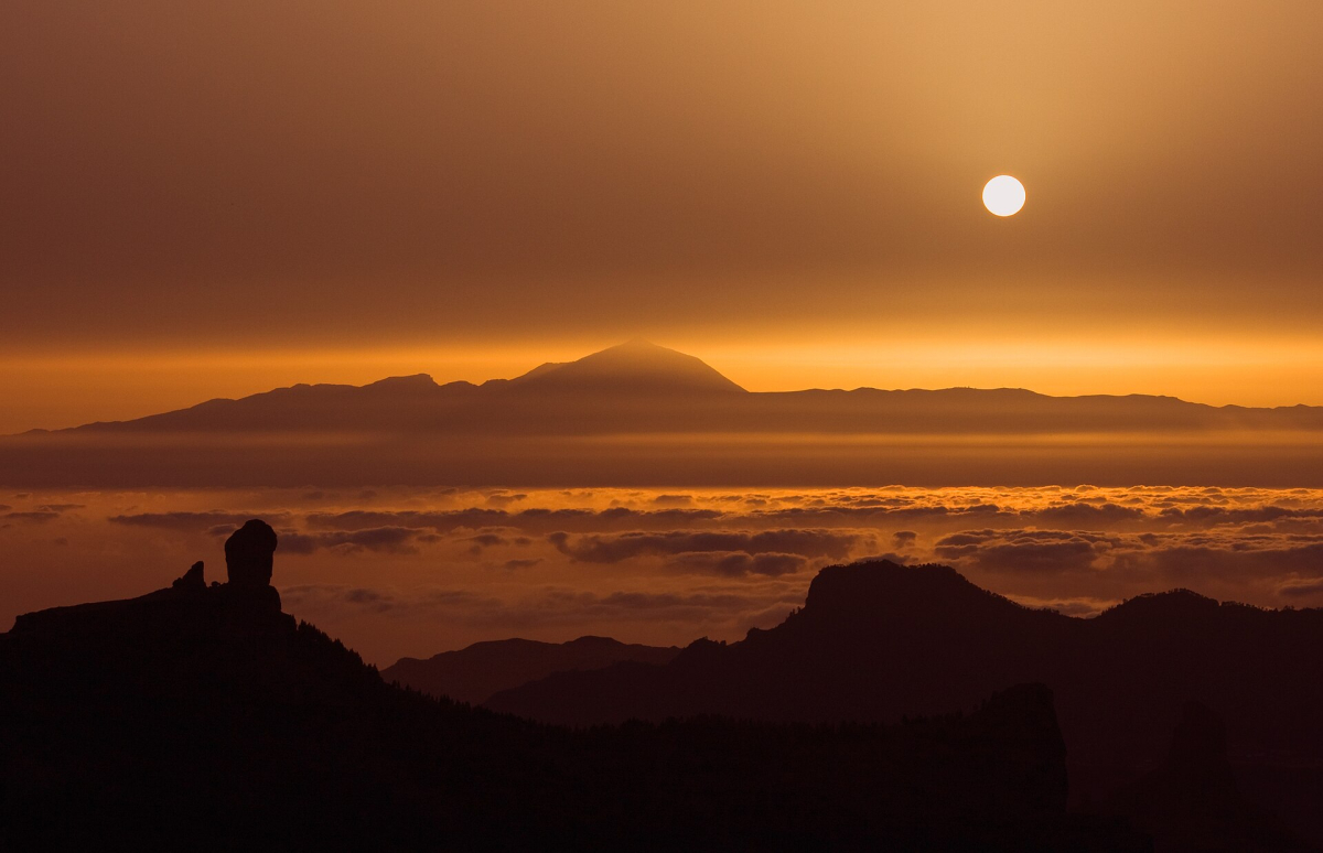 Roque Nublo and Teide in a hazy sunset view Roque Nublo and Teide in a hazy sunset view