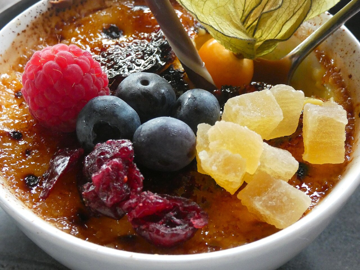 Crème brûlée with fruit, illustrating the custard dessert and caramelised surface.