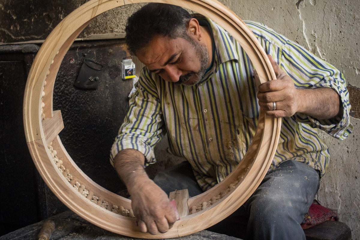 Woodworker shaping a circular wooden frame in Cairo Woodworker shaping a circular wooden frame in Cairo