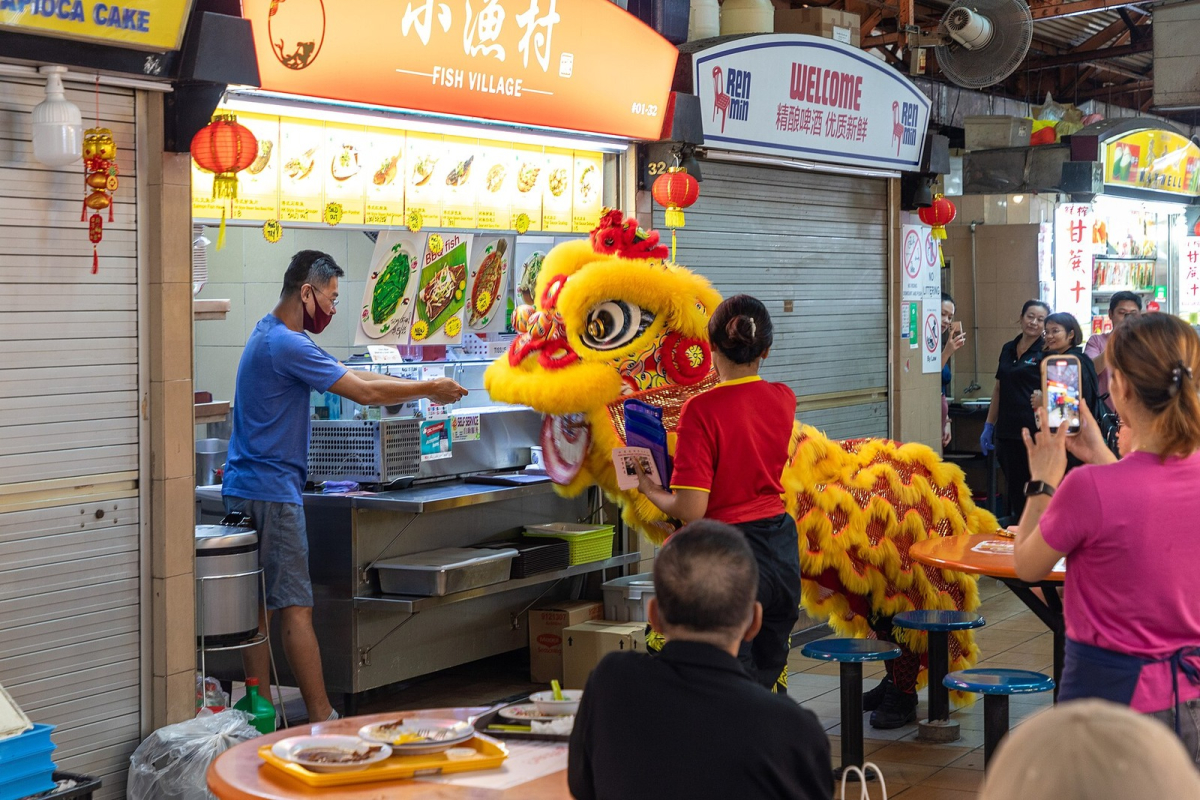 Chinese New Year good-luck procession at Maxwell Food Centre in February 2024. Historical festival scene, not the programme for a future year. Chinese New Year good-luck procession at Maxwell Food Centre in February 2024
