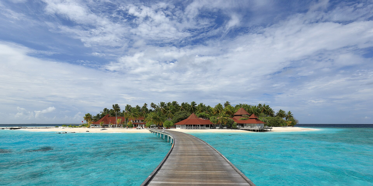 Curved boardwalk across the lagoon to Diamonds Thudufushi island Curved boardwalk across the lagoon to Diamonds Thudufushi island