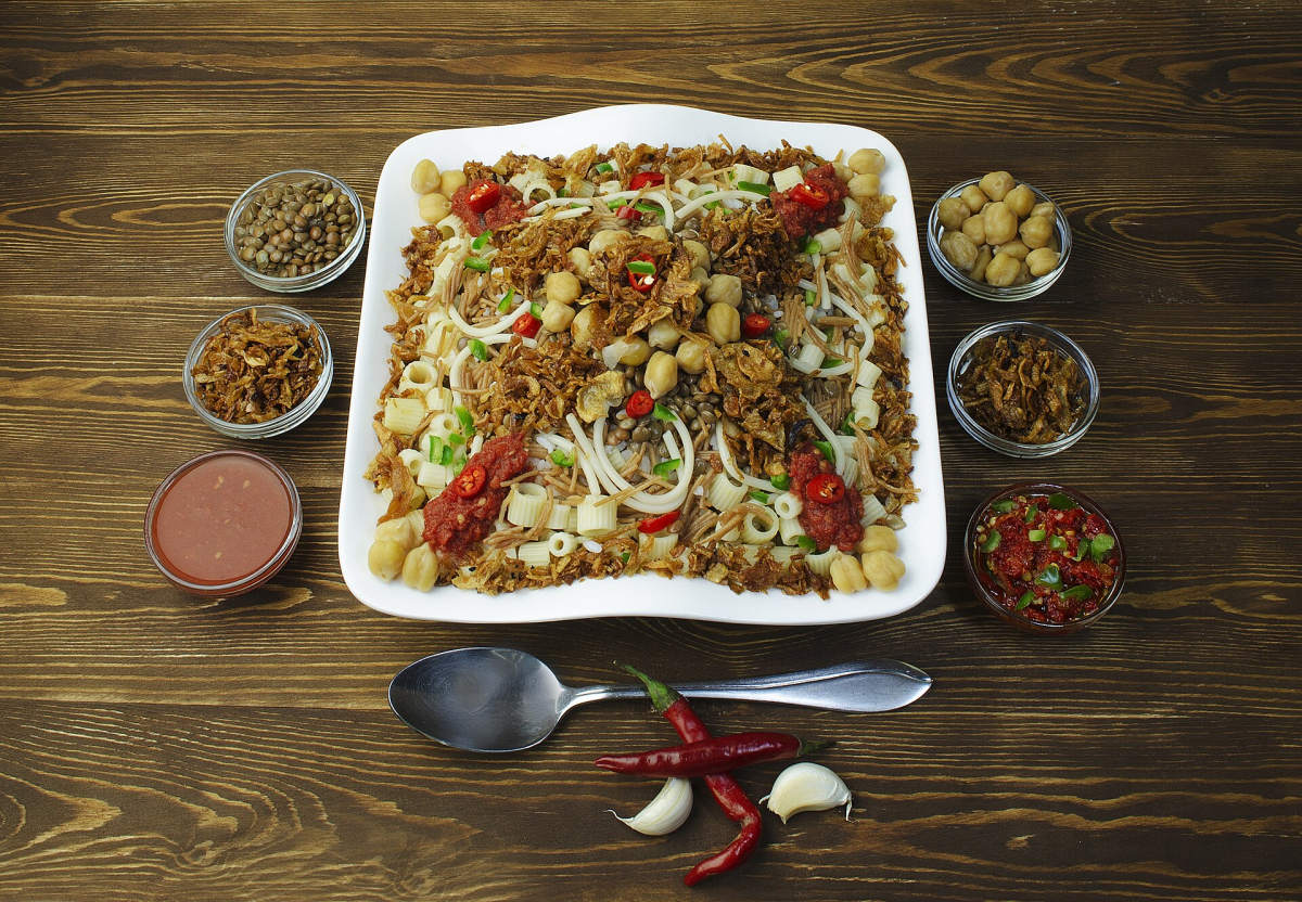 Plate of Egyptian koshary with sauces and toppings Plate of Egyptian koshary with sauces and toppings