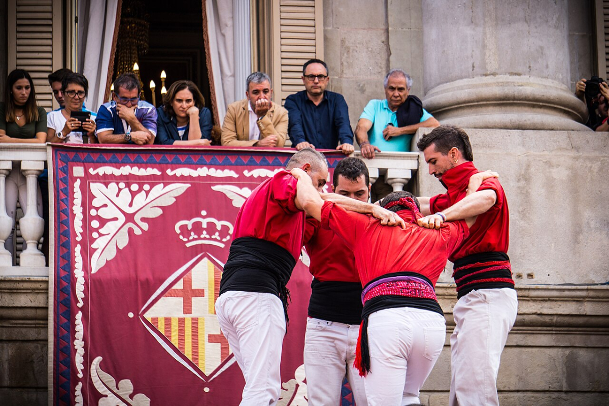 Castellers in red shirts preparing a formation during La Mercè in Barcelona