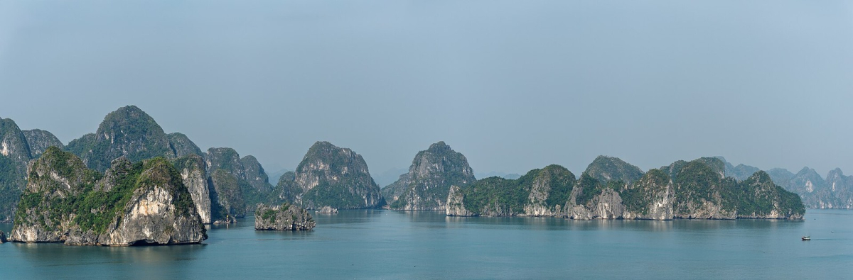 Ha Long Bay limestone islands seen in a broad coastal panorama.