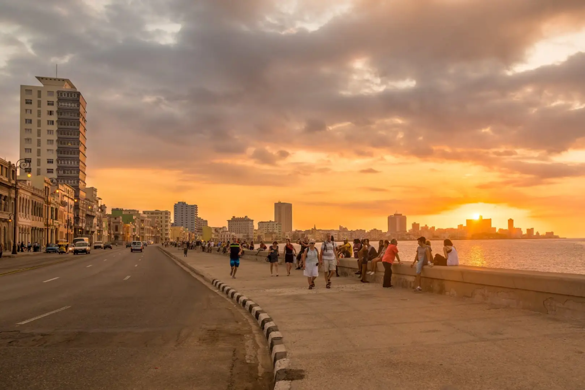 Traveler walking safely along Havana’s Malecón at sunset