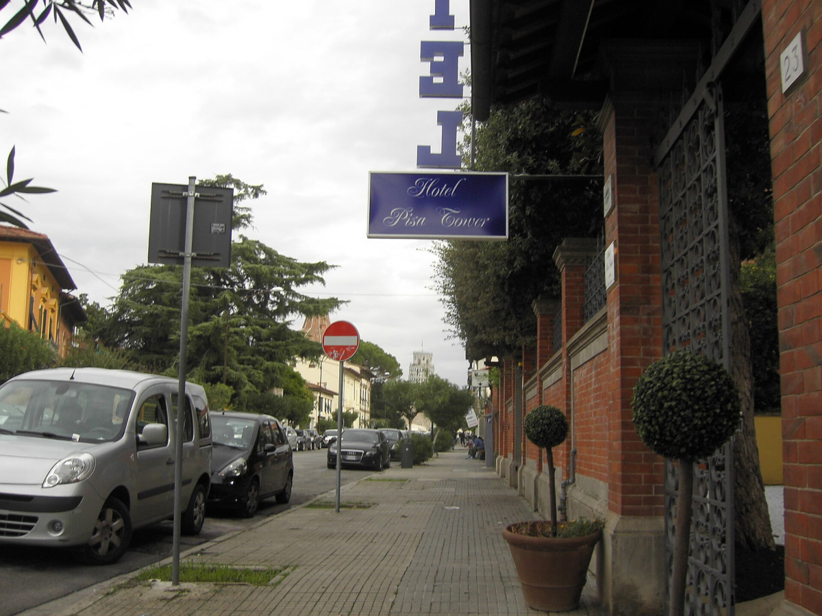 The signed entrance of Hotel Pisa Tower; confirm the building assigned to your booking.