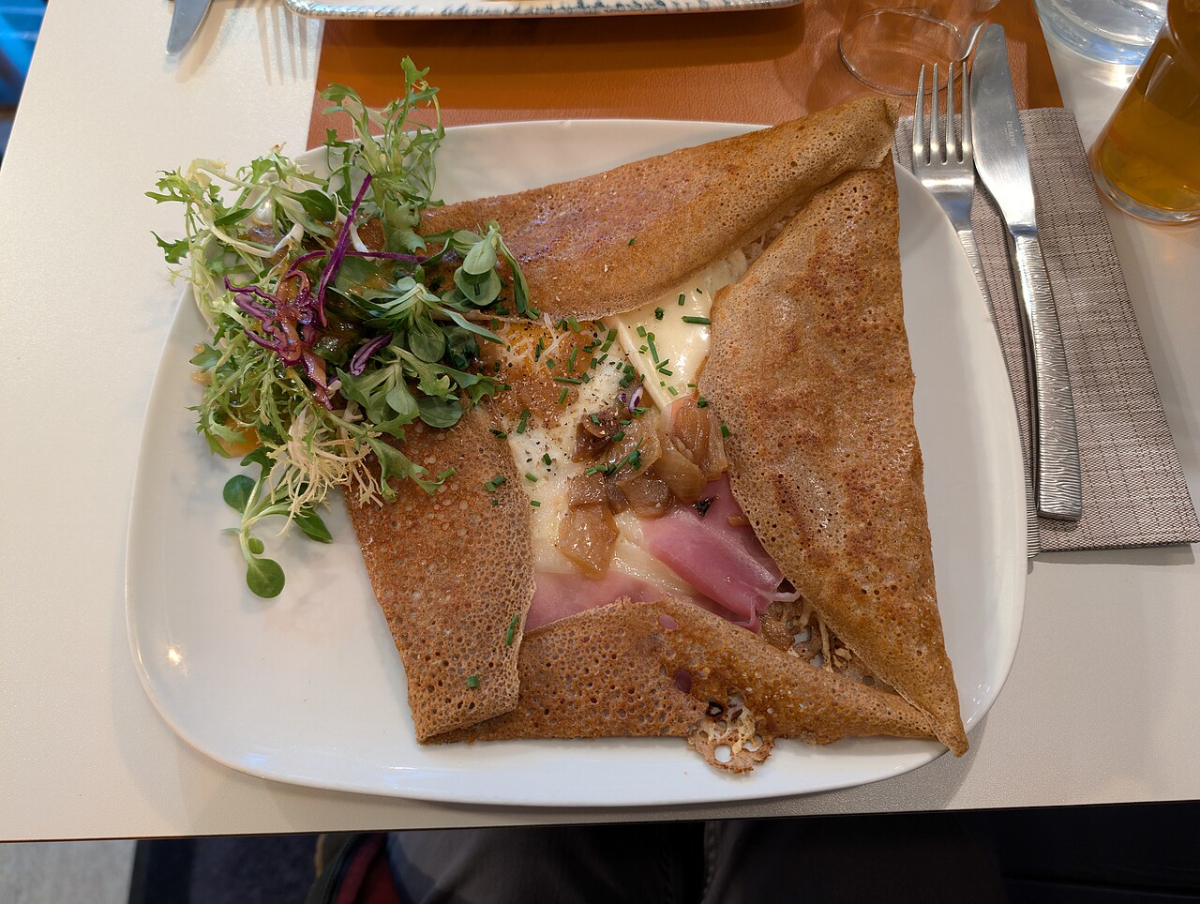 A savoury buckwheat galette with salad, illustrating a crêperie meal.
