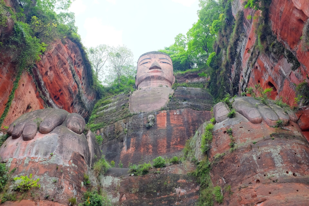 Leshan Giant Buddha seen between green and red sandstone cliffs Leshan Giant Buddha seen between green and red sandstone cliffs