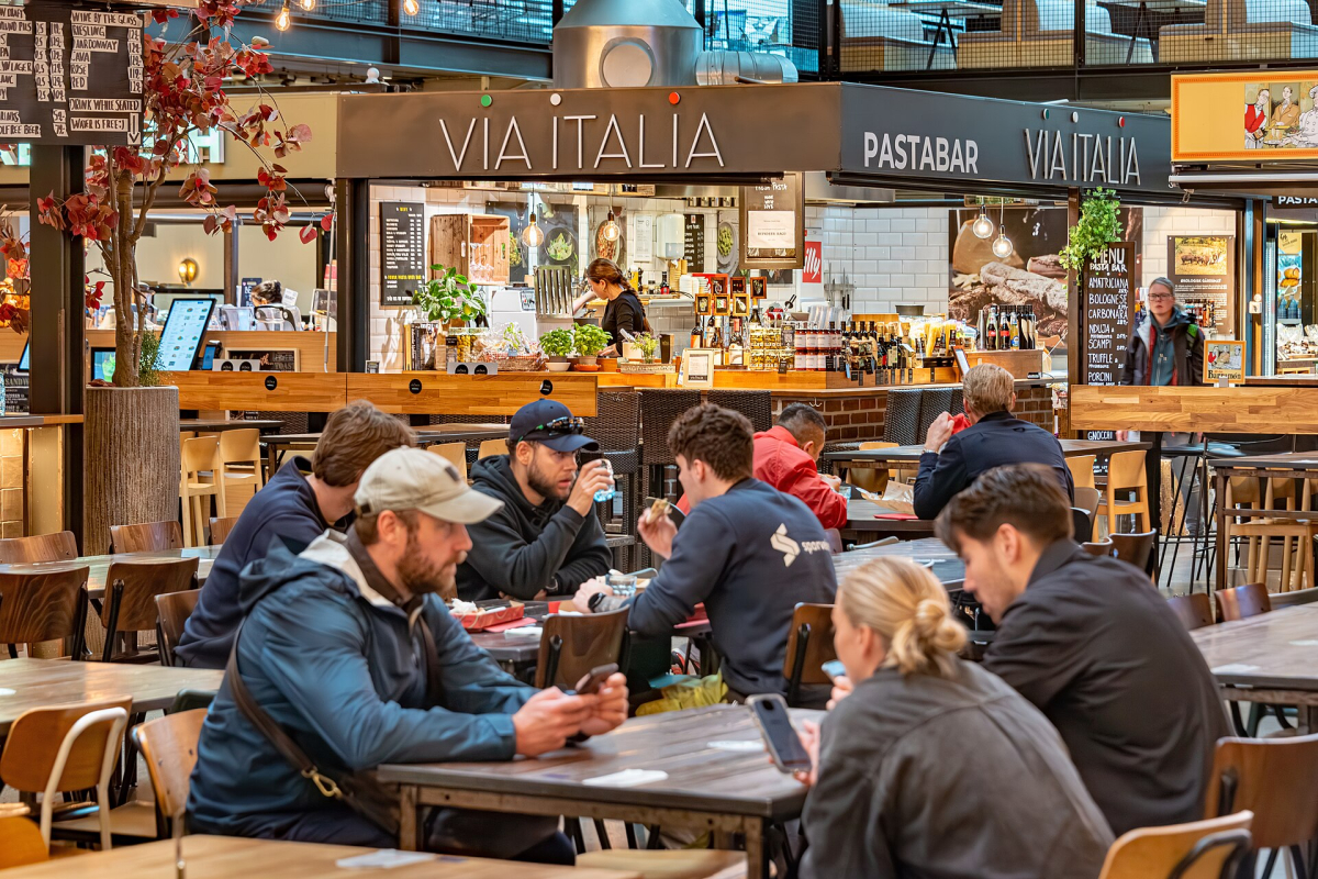 Tables and food stalls inside Mathallen, photographed in June 2026. Each trader has its own menu and prices. Tables and food stalls inside Mathallen, photographed in June 2026. Each trader has its own menu and prices.