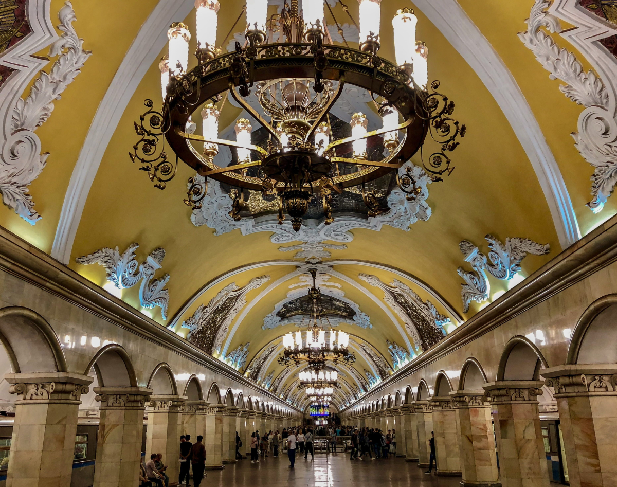 Passenger walking inside an ornate Moscow Metro station