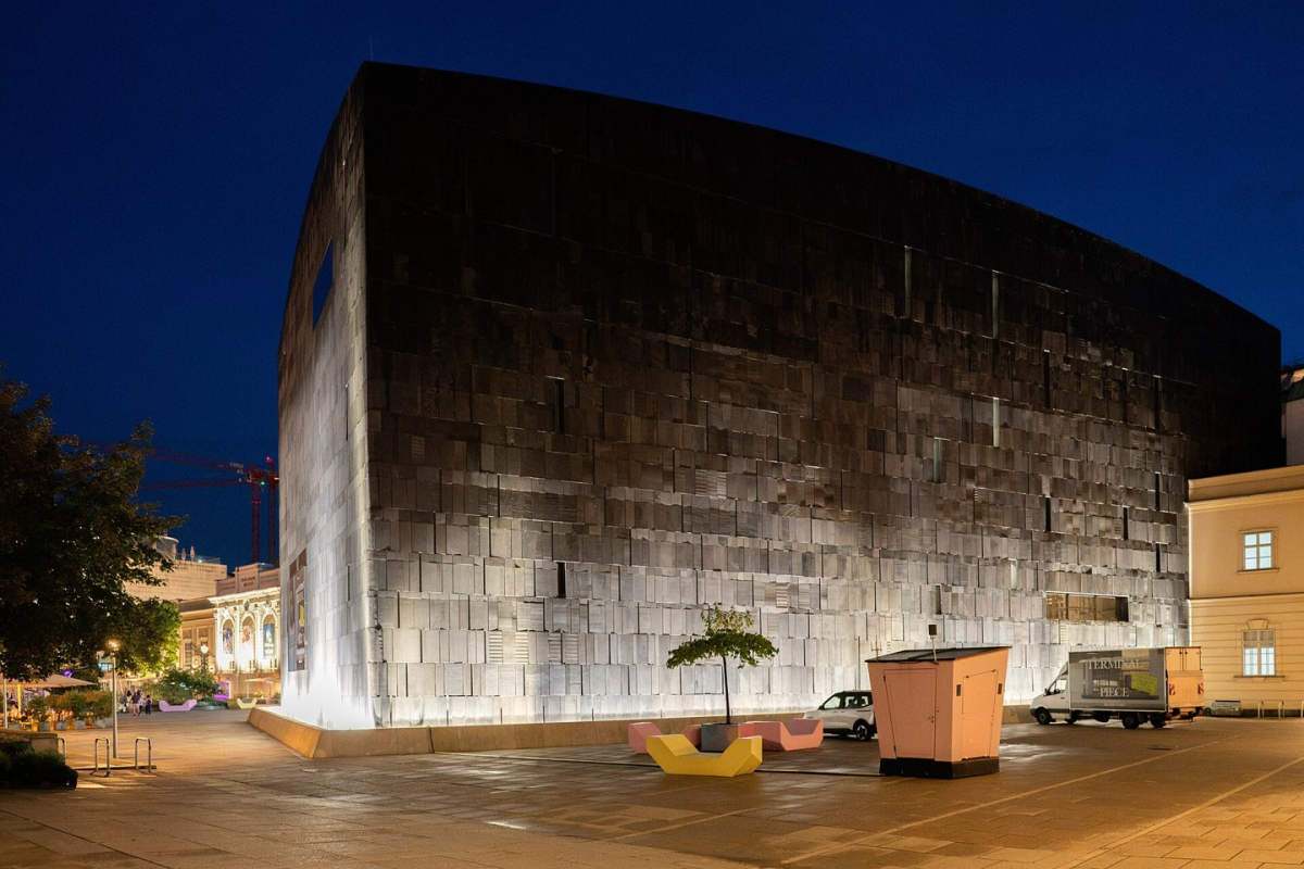 The dark stone mumok building illuminated at night
