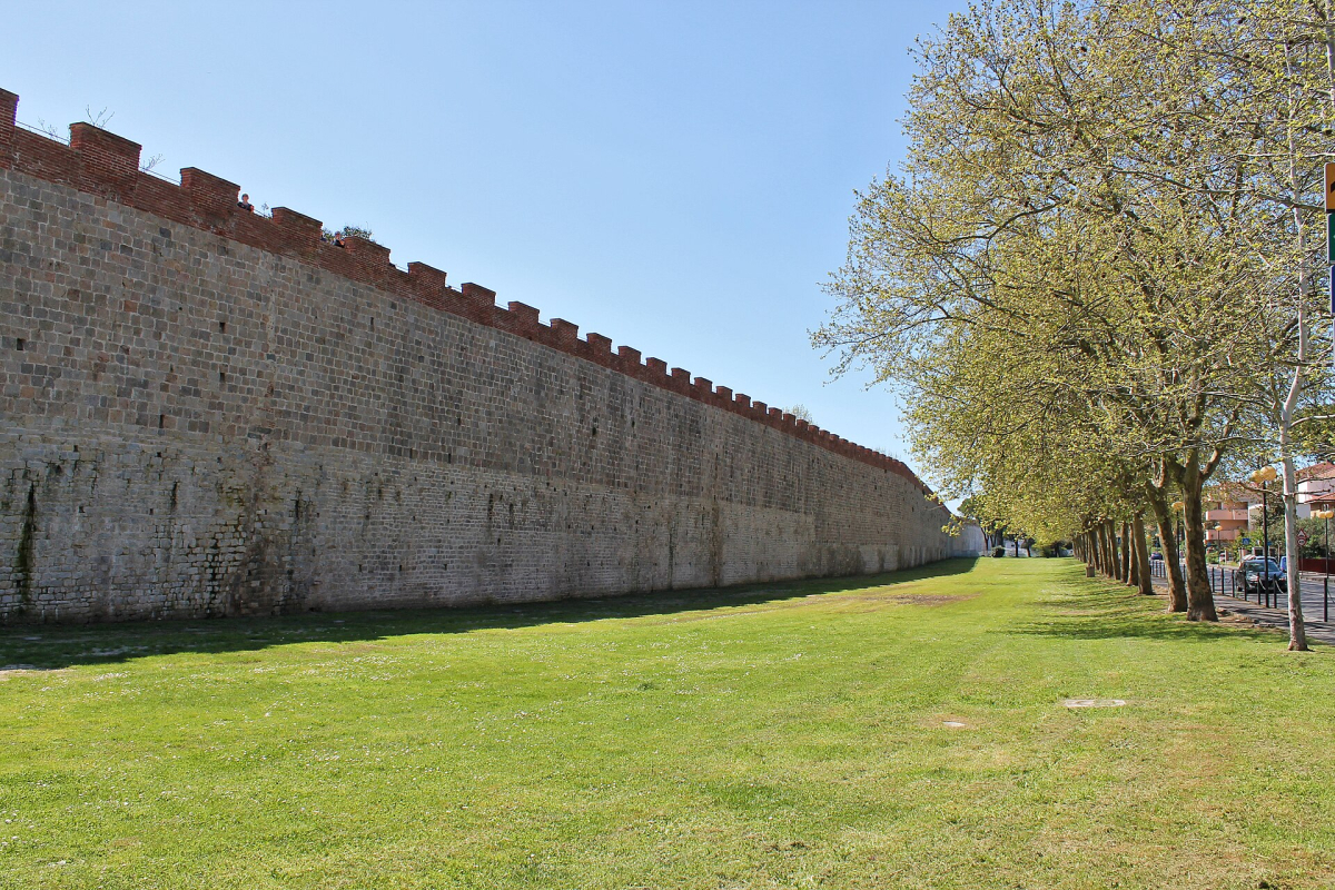 Pisa’s walls seen from ground level near Largo San Zeno; the elevated route has separate entrances.