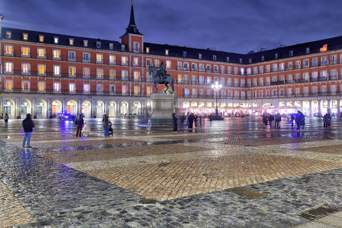Plaza Mayor in January 2026, with wet paving and illuminated façades.