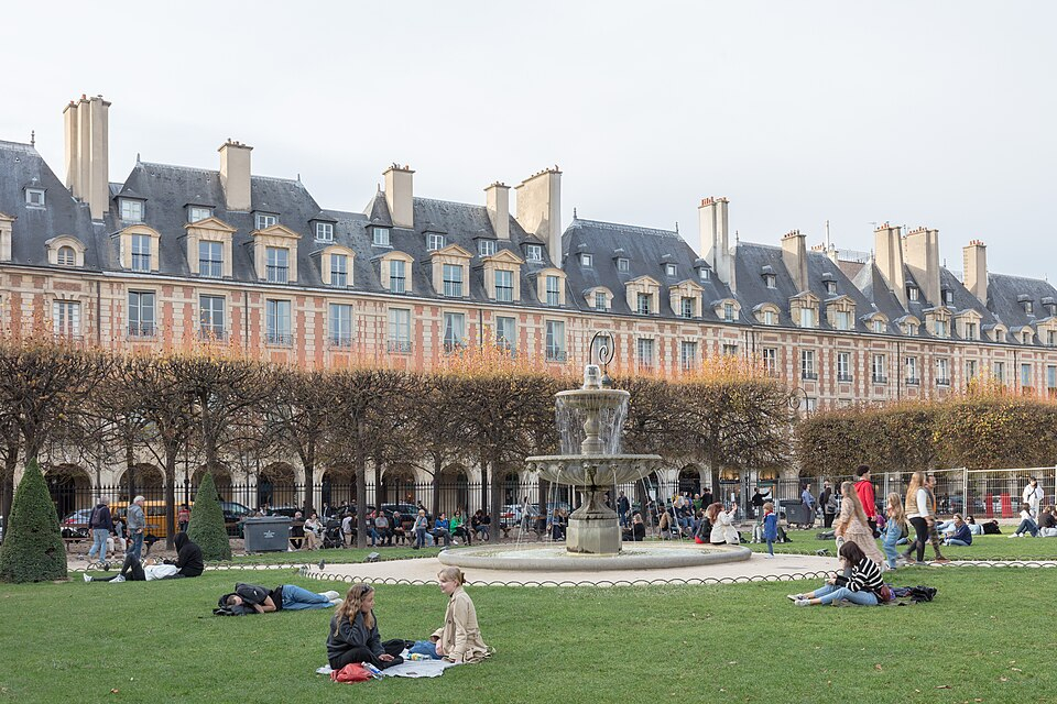 The lawns, fountain and brick façades of Place des Vosges.