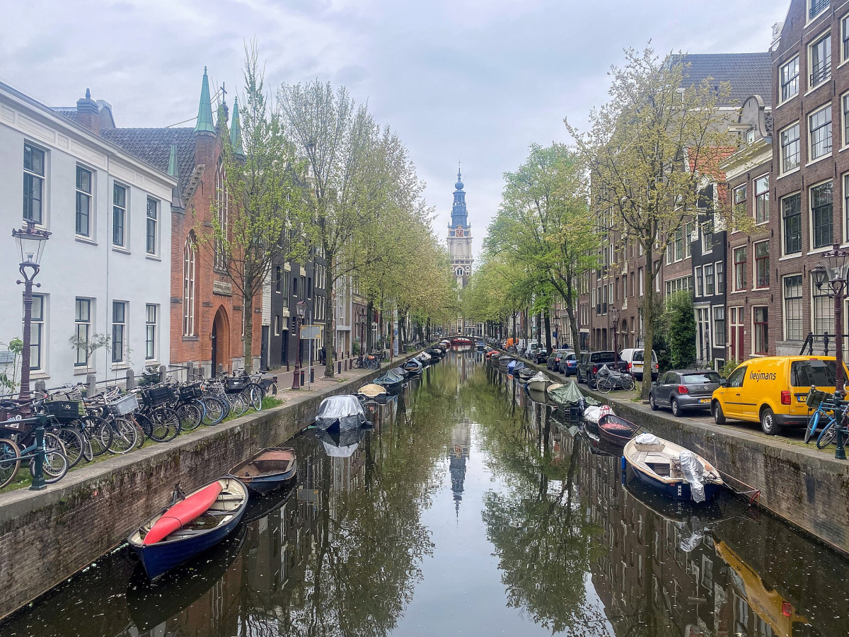 The Zuiderkerk tower framed by a canal view.