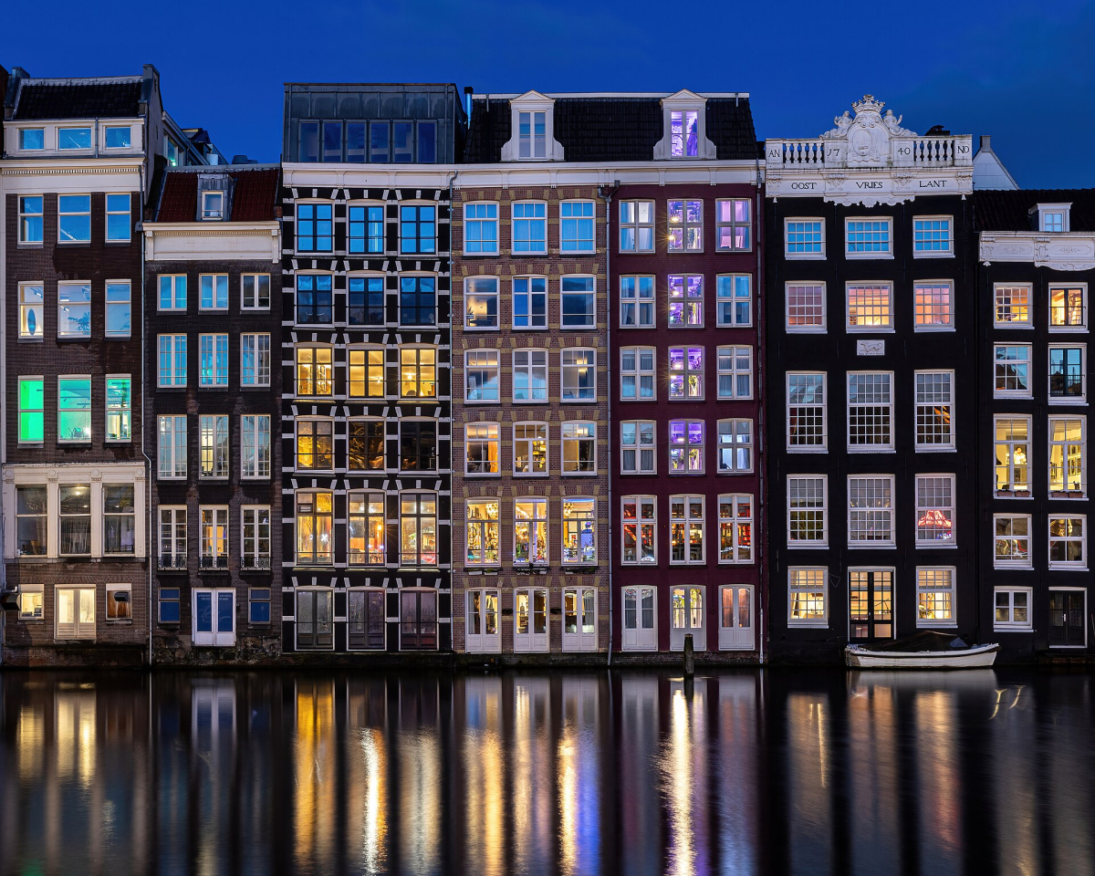 Damrak house fronts reflected at blue hour.
