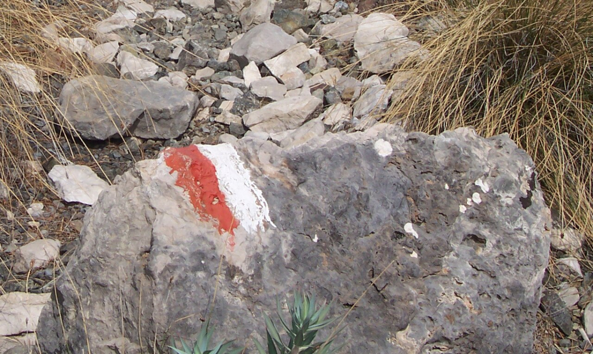 A red and white trail waymark painted on a rock along the Lycian Way