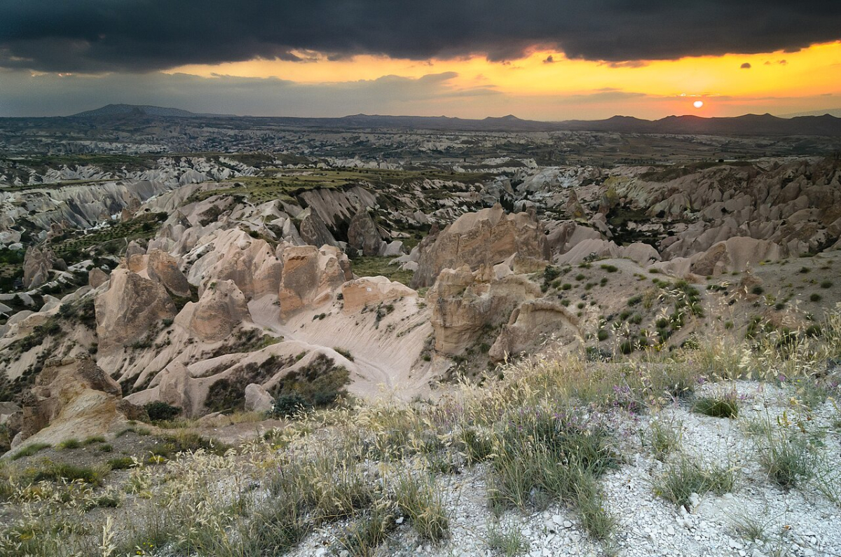The sun setting beyond the pale volcanic valleys of Cappadocia