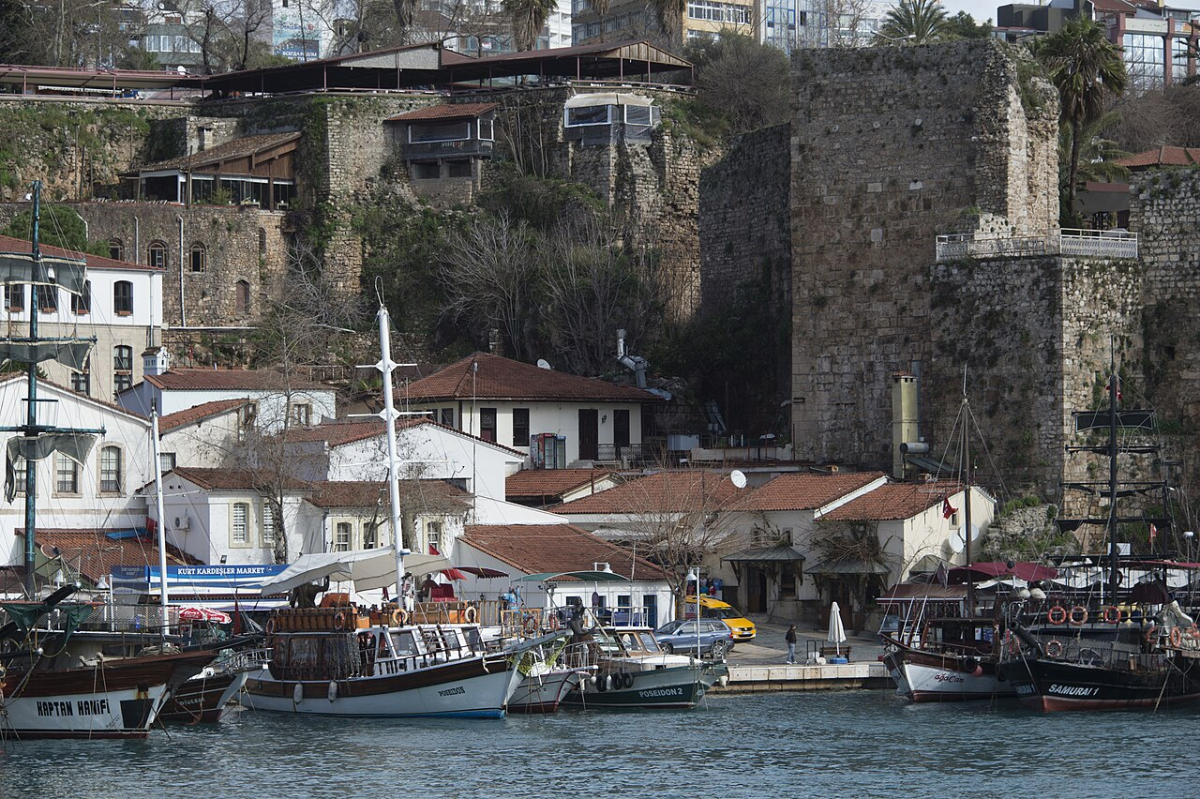 Boats moored beneath the stone walls of Antalya’s old harbour