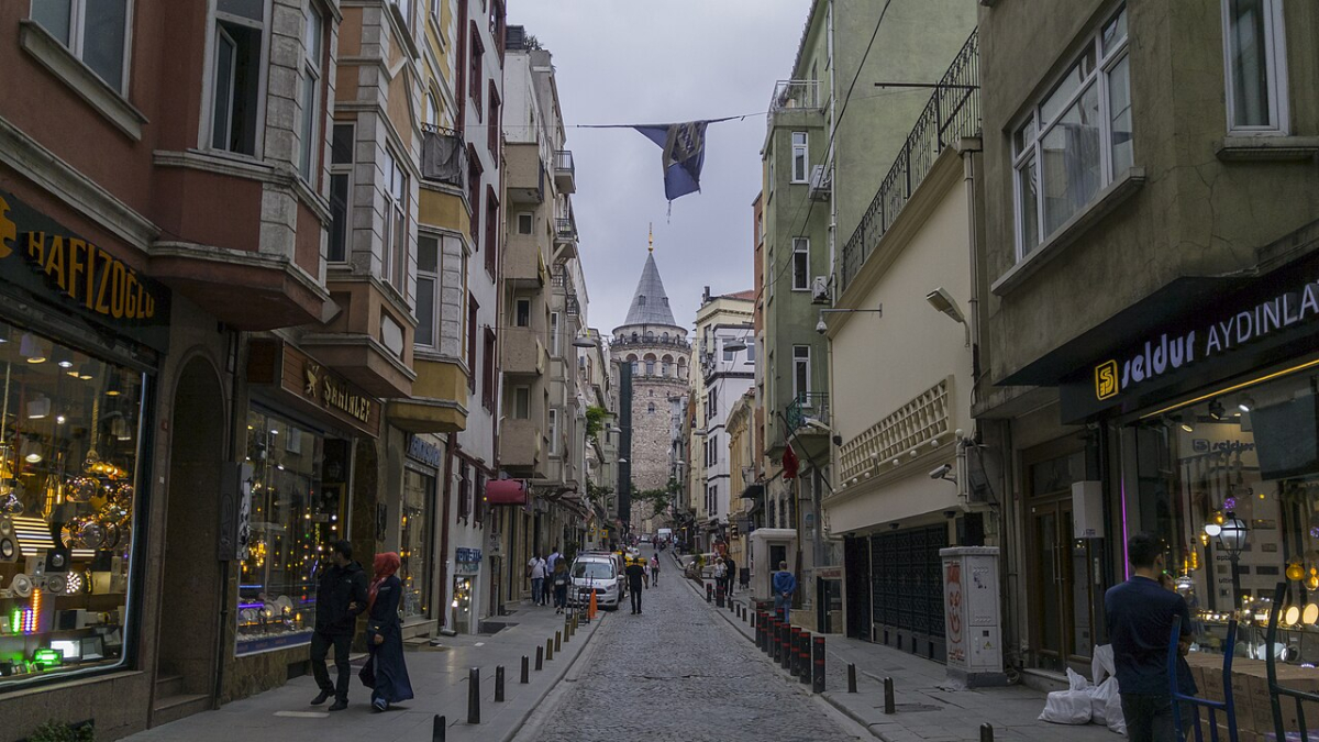 Galata Tower at the end of a street lined with shops in Istanbul