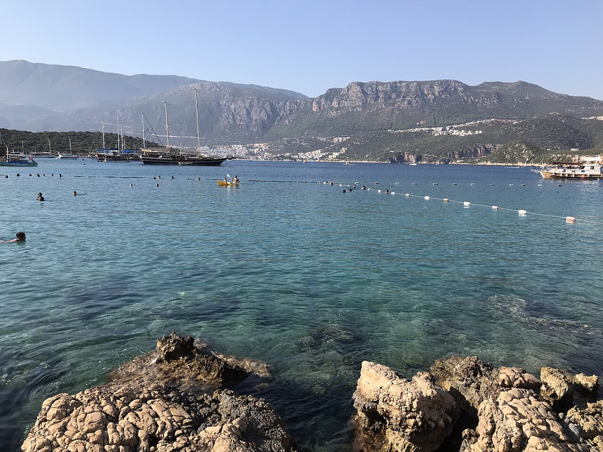 Swimmers and boats in the clear water at Limanağzı near Kaş