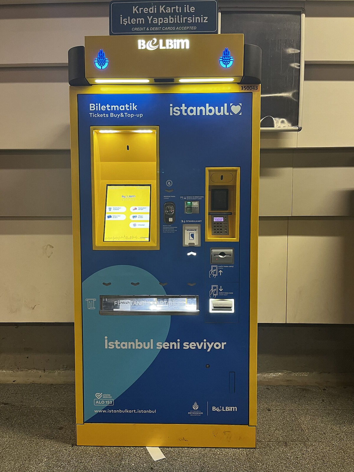 A yellow and blue Istanbulkart ticket purchase and top-up machine