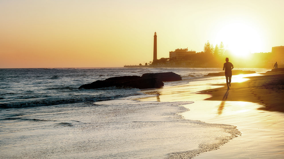 Maspalomas Dunes and lighthouse in Gran Canaria at sunset