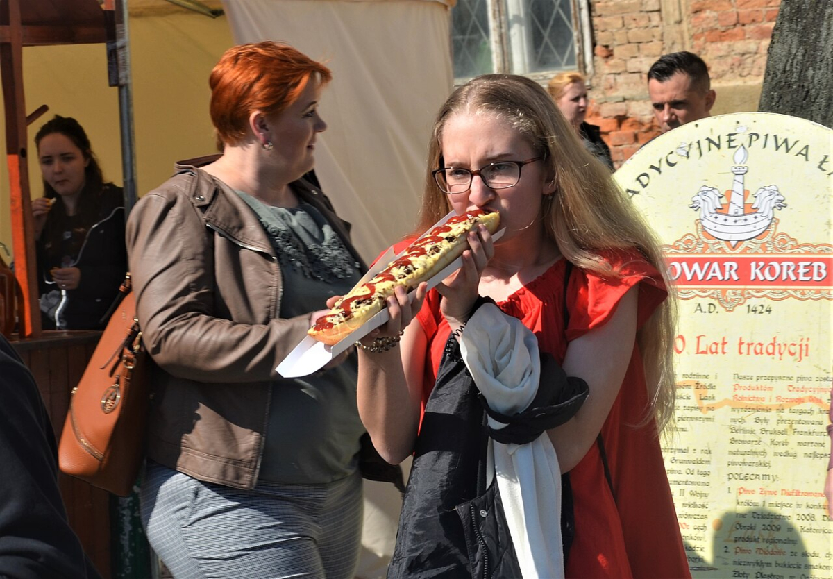 A large zapiekanka held ready to eat A large zapiekanka held ready to eat