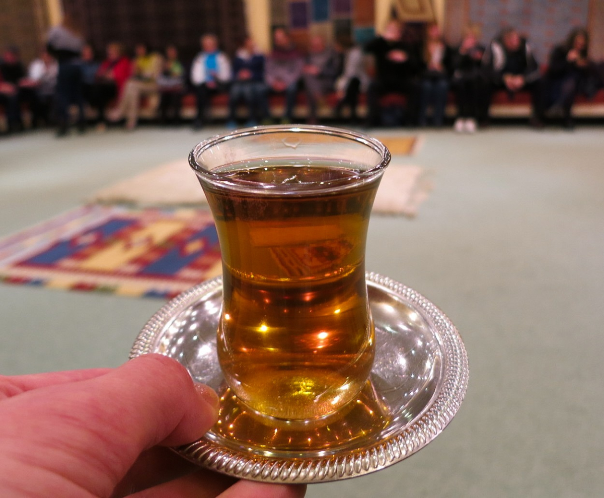 Turkish black tea in a tulip-shaped glass on a metal saucer