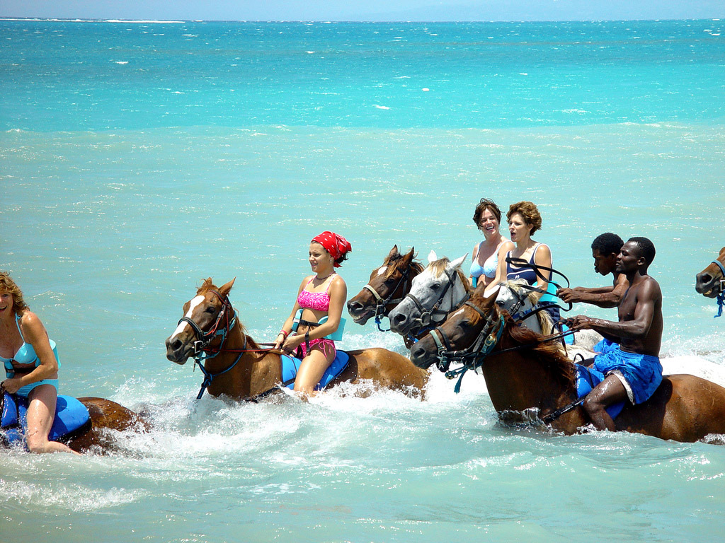 Travelers enjoying horseback riding in the sea in Jamaica, one of the island’s unique outdoor activities