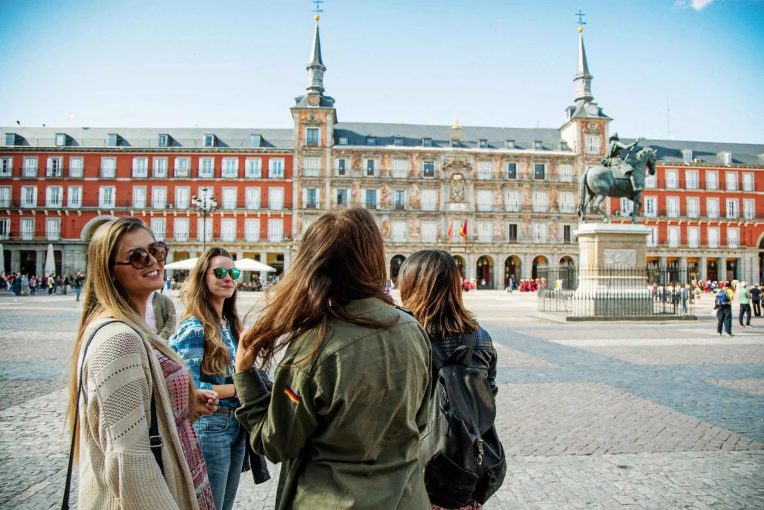 Travelers exploring Plaza Mayor in Madrid on a sunny day