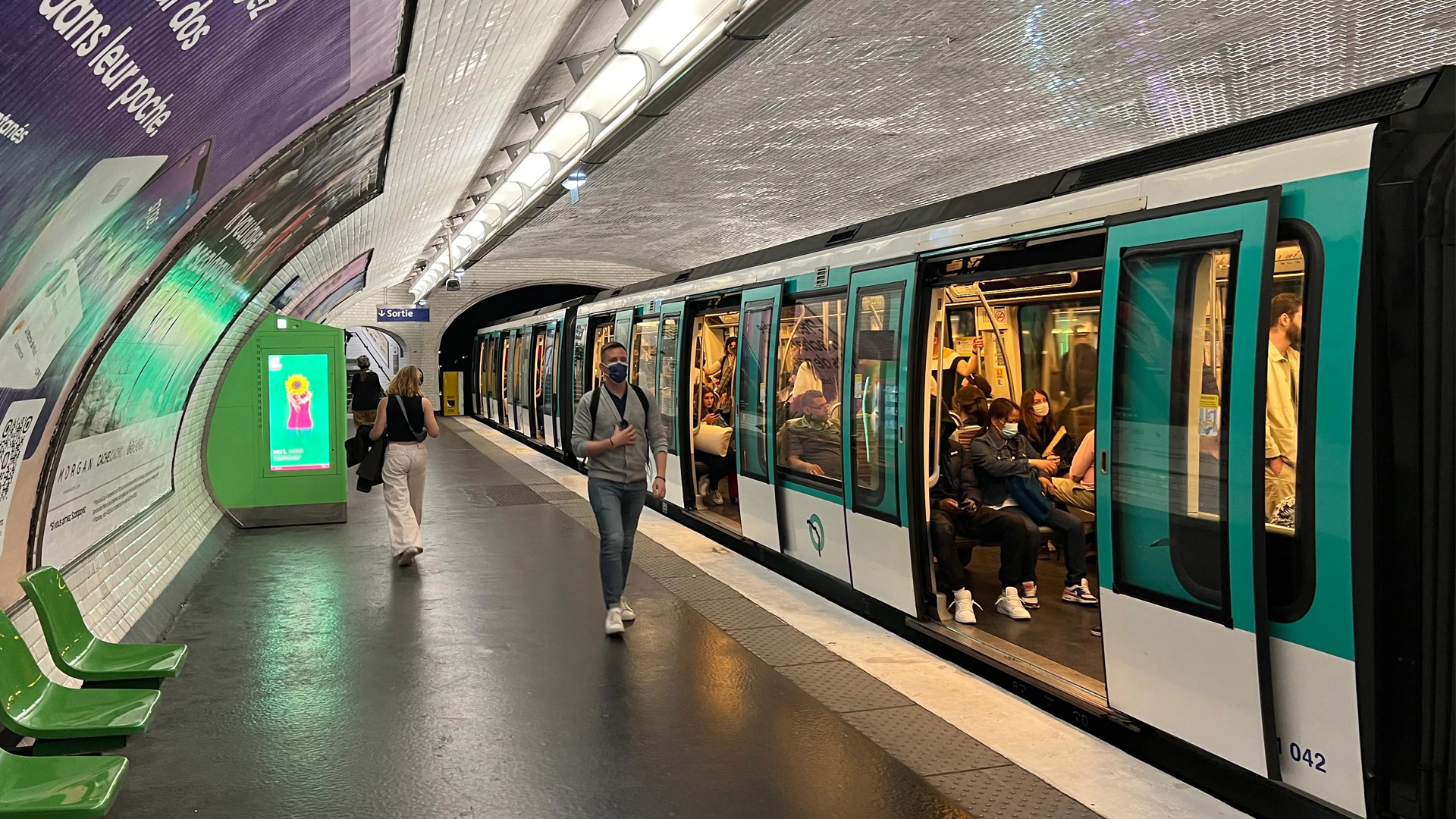 Passengers boarding a Paris Metro train at an underground station